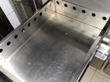 a stainless steel oven that is open on a tiled floor