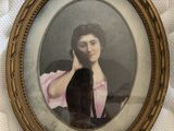 une vieille photo d'une femme en robe rose tenant un chat noir
