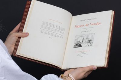 une personne tient un livre dans ses mains, posée sur une surface noire