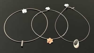 une paire de boucles d'oreilles créoles ornées d'une fleur de chaque côté