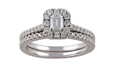 une bague de fiançailles en or blanc sertie d'une émeraude en centre