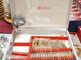a box of silverware on a table with a red table cloth