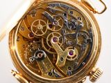 a close up of a gold pocket watch with a white background