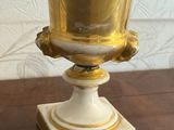 a gold vase sitting on top of a wooden table