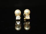 une paire de boucles d'oreilles en perles et diamants sur fond noir