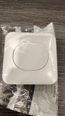 une boîte blanche munie d'un bouton, posée sur une table