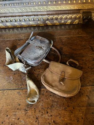 un sac à main et d'autres objets posés par terre à côté d'une valise
