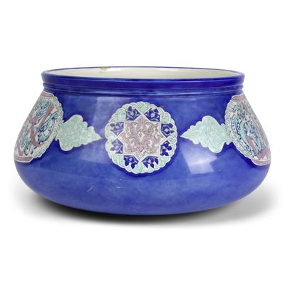 un bol bleu orné d'un motif sur fond blanc