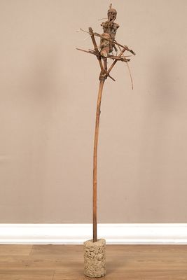 une sculpture représentant un squelette assis sur une plante