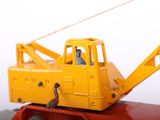 a yellow toy truck with a crane on top of it