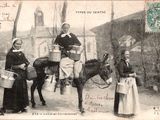 une vieille carte postale représentant trois femmes et un âne sur un chemin de terre