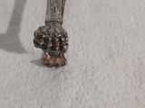 une cuillère en argent posée sur une table blanche