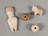 trois figurines en bois représentant des personnages et une balle posées sur une surface grise