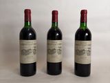 three bottles of wine are lined up on a table