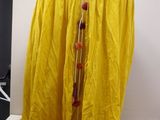 a yellow cloth draped over a table with a lamp on it