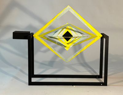 an image of a yellow and black glass sculpture on a stand