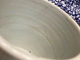 a white bowl sitting on a blue and white table cloth