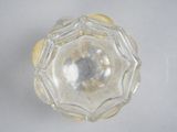 a clear glass object on a white surface