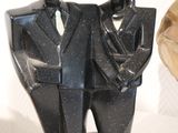 two statues of a man and a woman dressed in tuxedos