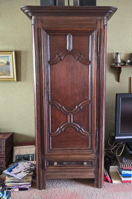 une grande armoire en bois dans un coin du salon