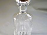 a clear glass bottle with a stopper sitting on a table