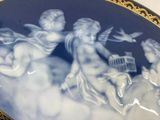 a plate with a picture of angels and a bird on it