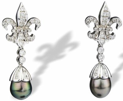 une paire de boucles d'oreilles en perles noires et diamants sur fond blanc