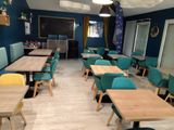 many tables and chairs in a restaurant with blue walls