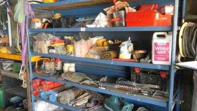 a blue shelving with lots of tools on top of it