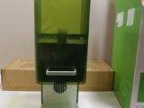 a green water dispenser sitting on a table next to a cardboard box