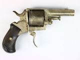 an old revolver with a wooden handle on a white surface