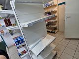 a person standing in front of a store shelf with empty shelves