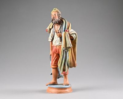 figurine représentant un homme barbu vêtu d'une robe, debout sur un socle en bois
