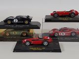 three red and black model cars are on display in glass cases