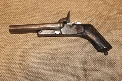 un gros plan d'un pistolet posé sur une table, avec un fond en tissu