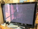 une télévision à écran plat posée sur une table en bois