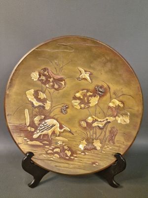 une assiette décorative ornée d'un oiseau et de fleurs