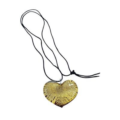 a close up of a gold heart pendant on a black cord