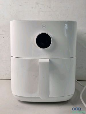 a white air fryer sitting on a counter next to a white wall
