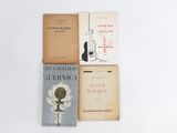 several books are stacked on top of each other on a white surface