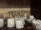 many cups and saucers sitting on a wooden table