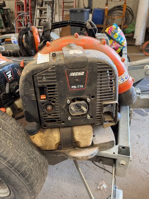 une tronçonneuse posée sur un chariot dans un garage