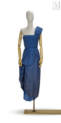 mannequin vêtu d'une robe bleue, exposé sur un socle en bois