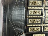 a black and gold chest of drawers with a door open