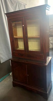 une vieille armoire en bois avec des portes vitrées dans une pièce