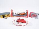 une petite voiture rouge et d'autres véhicules miniatures dans une boîte