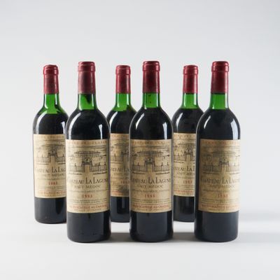 six bouteilles de vin sont alignées sur une surface blanche