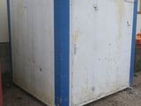 a white and blue refrigerator sitting outside of a building
