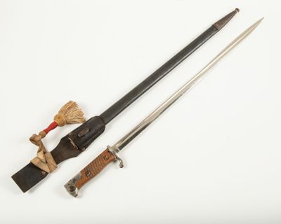 une vieille épée et un couteau posés sur une surface blanche