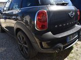 a black mini cooper parked in a parking lot